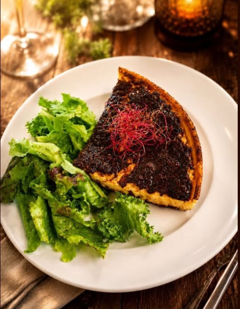 Part de tarte salée servie avec une salade verte du jardin de Courtemelon